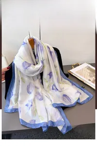 Detailed view of floral silk scarf featuring purple tulips on white background with blue borders