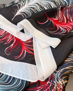 Nahaufnahme des Seidenschals mit Federmuster, elegantem Faltenwurf und buntem Design