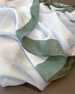 Vue détaillée des coutures fines et du tissu lisse effet soie du foulard floral