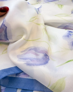 Detailed close-up of floral silk scarf with lavender tulip patterns and soft texture