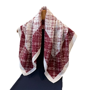 Women's plaid cotton linen scarf in burgundy and cream hanging on a wooden hanger