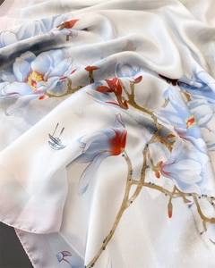 Détail d'un foulard soyeux avec élégant imprimé floral magnolia bleu et bords lisses