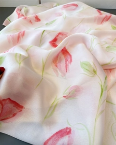 Detail of floral silk scarf featuring translucent watercolor pink flowers and green leaves