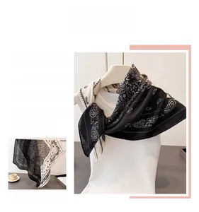 Macro detail of elegant black and white paisley pattern scarf with silky texture finish