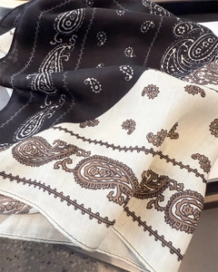 Detailed macro view of paisley pattern print on a soft dual-tone cotton linen scarf