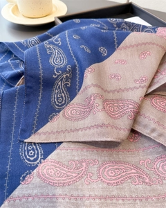 Detail of paisley pattern on blue and grey herringbone wool feel scarf in a cozy setting