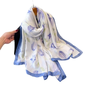 Silky fashion scarf with floral patterns and blue borders on a white satin base