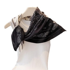 Elegant black and cream paisley print neck scarf on a mannequin with a white ribbed top