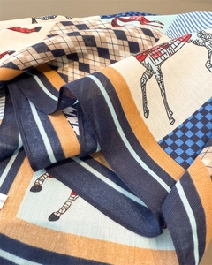 Dettaglio macro di un foulard quadrato in twill con stampa a cavalli e motivi geometrici