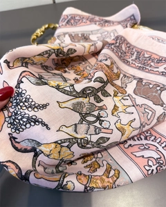 Close-up of pink silk scarf with retro animal patterns and twill weave texture detail