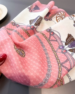 Detailed view of pink and white scarf featuring vintage gold chains and horse carriage motifs