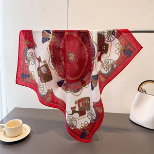 Detail of vintage square scarf with red and gold horse carriage pattern on metal hanger
