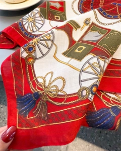 Macro detail of silk scarf showing vintage carriage wheel patterns and twill weave texture