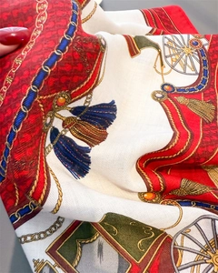Detailed macro of vintage pattern silk scarf with golden chains and carriage wheel motifs