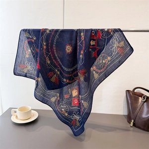 Close-up of navy silk scarf with classic horse carriage pattern and tassels on metal rack