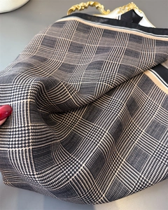 Detailed view of plaid herringbone pattern silk scarf with soft drape and weave texture