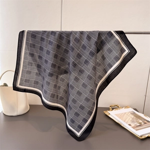 Classic houndstooth check scarf with black border hanging elegantly in minimalist setting