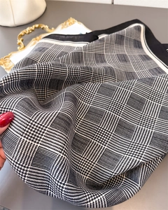 Close-up of black and white houndstooth scarf with fine twill texture and soft silk feel