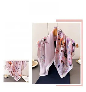 Detailed view of the elegant pink floral pattern on soft silk-like fabric scarf