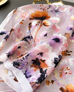Detail of floral printed scarf showing light pink and purple twill texture and drape