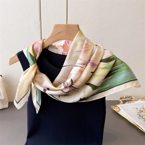 Floral print silk scarf with satin finish styled on navy blue top for elegant women