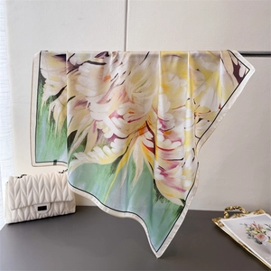 Elegant floral silk square scarf with soft pastel flower prints hanging in a stylish room