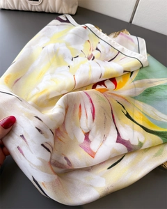 Detailed view of floral silk scarf featuring elegant yellow and red blossom patterns