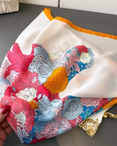 Detailed view of floral silk scarf featuring vibrant poppies and orange hand-rolled edges