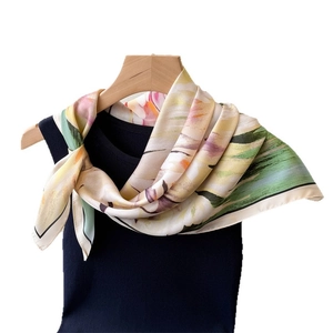 Elegant floral print faux silk scarf displayed on a black top and wooden hanger