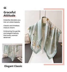 Detail of light green floral silk scarf with elegant white patterns and dark green hem
