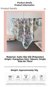 Macro view of blue floral print silk scarf with satin texture and detailed hem stitching