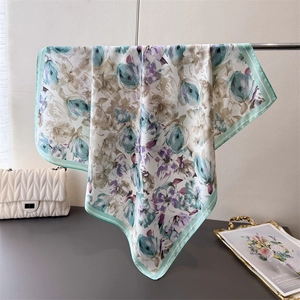 Detail of floral silk-like scarf with mint green borders and artistic flower patterns