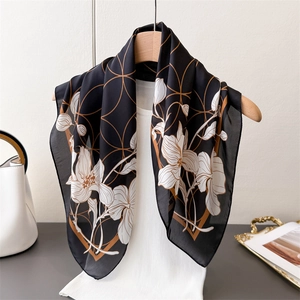 Detail of silk-like floral square scarf draped on hanger showing smooth satin texture and drape
