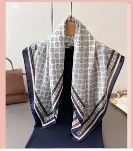Detail of silk-like scarf with geometric print hanging elegantly on a wooden hanger