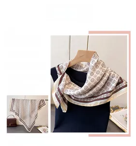 Detail of silk-feel scarf featuring retro geometric patterns and brown diamond motifs