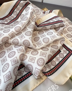 Close-up of geometric silk scarf fabric showing retro patterns and soft texture