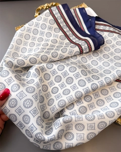 Close-up of geometric silk scarf with mandala patterns on a vintage gold tray