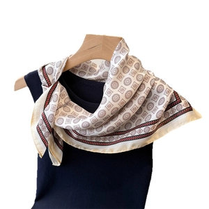 Elegant silk scarf with geometric circles and red borders on a black knit top