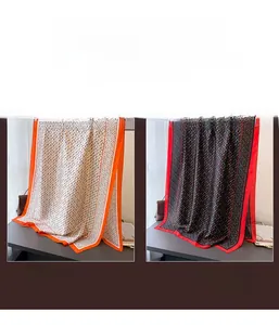 Detail of geometric pattern on lightweight silk scarves in beige and black variants