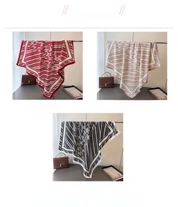 Detail showing red, khaki and black striped silk-like square scarves with letter patterns