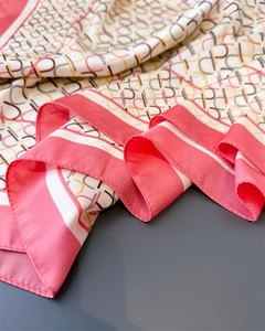 Detail of silk-texture scarf showing interlocking geometric patterns and pink border edge