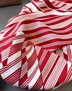 Close-up of red and white striped silk scarf with elegant drape and satin luster