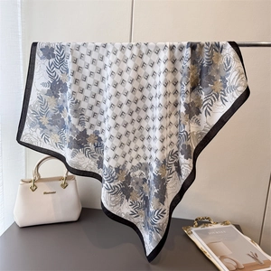 Dettaglio del motivo floreale vintage e monogramma F sul foulard quadrato in seta morbida