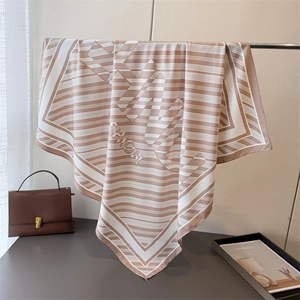 Detailed texture of mocha brown striped silk scarf with elegant FASHION lettering