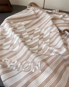 Detail of khaki striped silk scarf featuring large fashion typography and satin finish