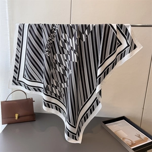 Detail showing the elegant drape of a silk scarf with classic black and white stripes
