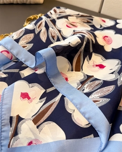 Detail eines Seidenschals mit großen weißen Blumen auf dunkelblauem Hintergrund