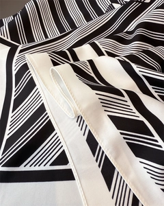 Close-up of black and white striped silk scarf with twill texture and hand-rolled edges