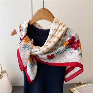 Foulard quadrato in finta seta con stampe floreali vintage e bordi rossi su un manichino