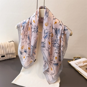 Eleganter Seidenschal mit Blumenmuster und Gänseblümchen-Print für Damen am Mannequin